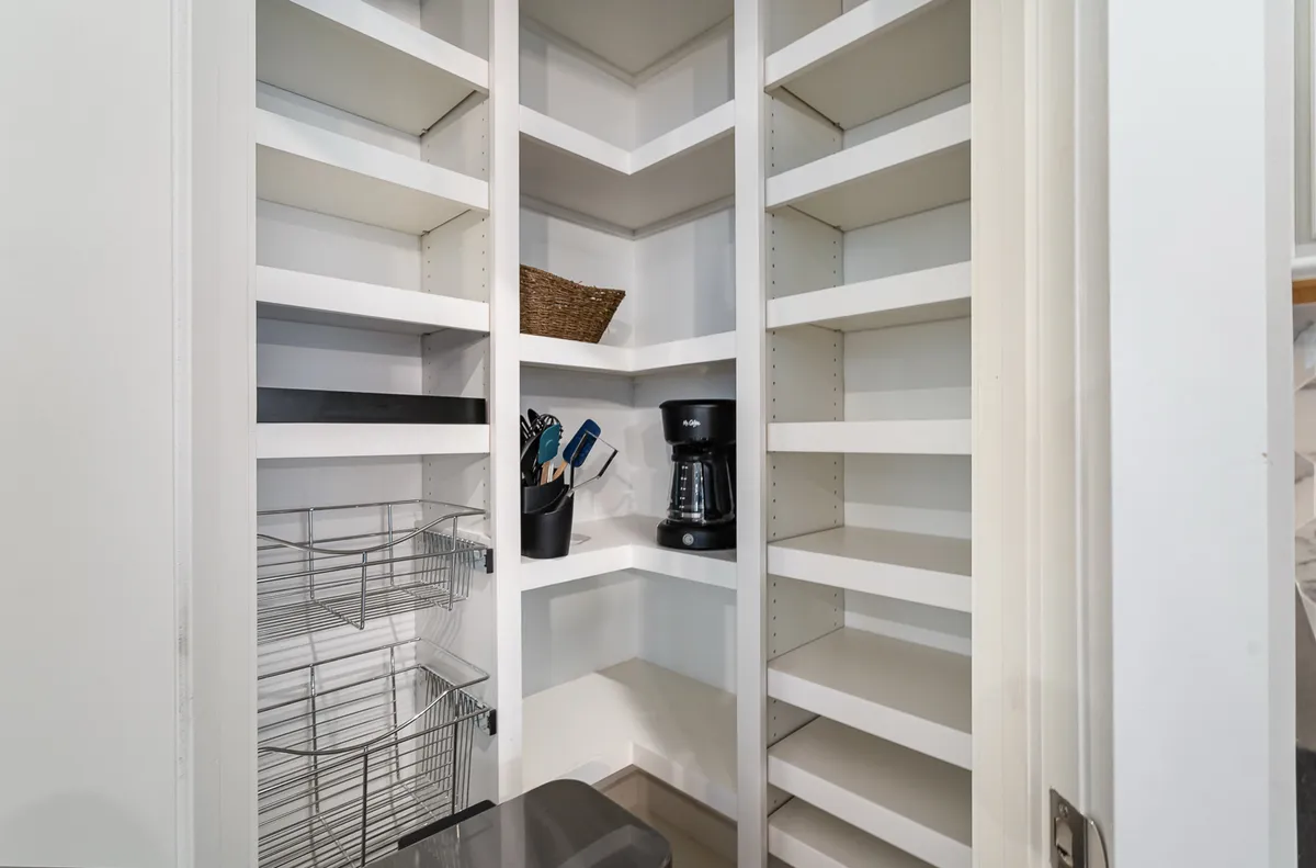 This image spotlights practical kitchen shelving, a coffee maker, kitchen tools, a basket, and a wire rack—showcasing the kind of kitchen amenities and organizational features guests can expect on arrival.